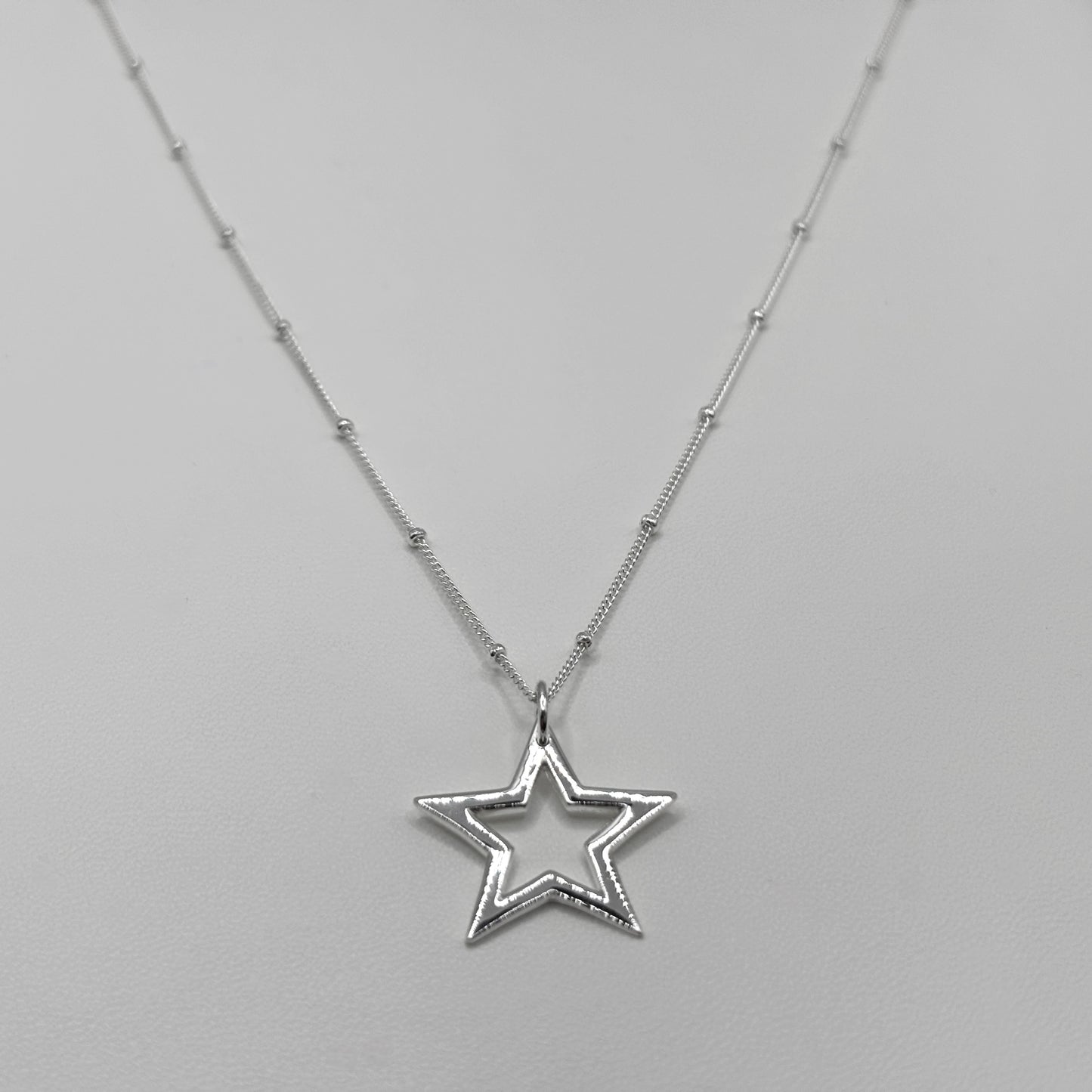 Cut-Out Star Pendant on a Satellite Chain